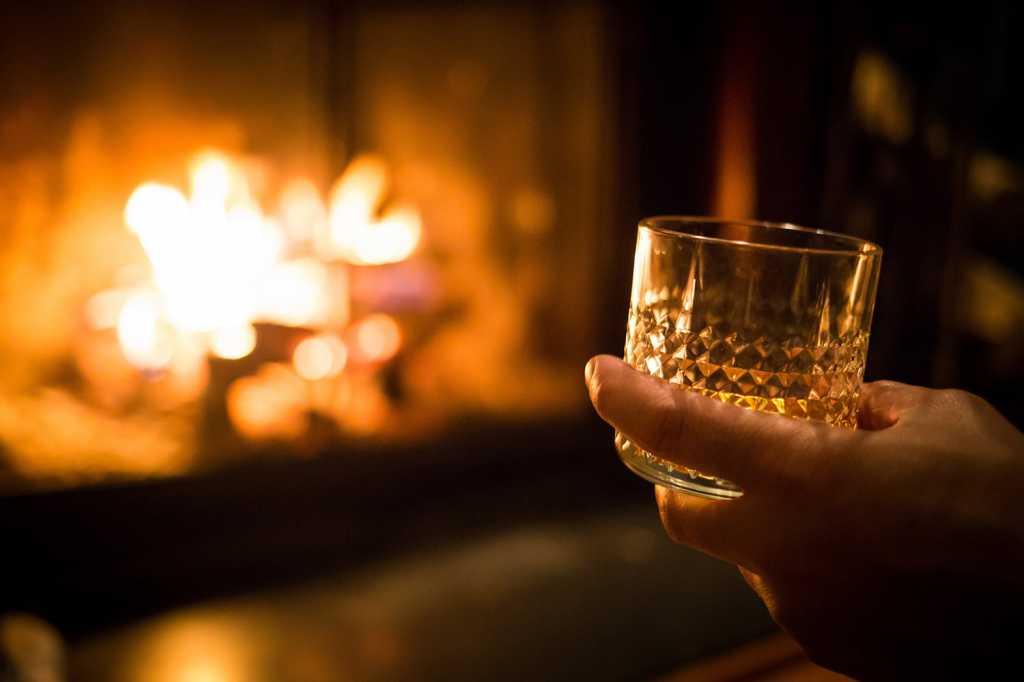 hand-holding-whiskey-glass-at-fireplace.jpg